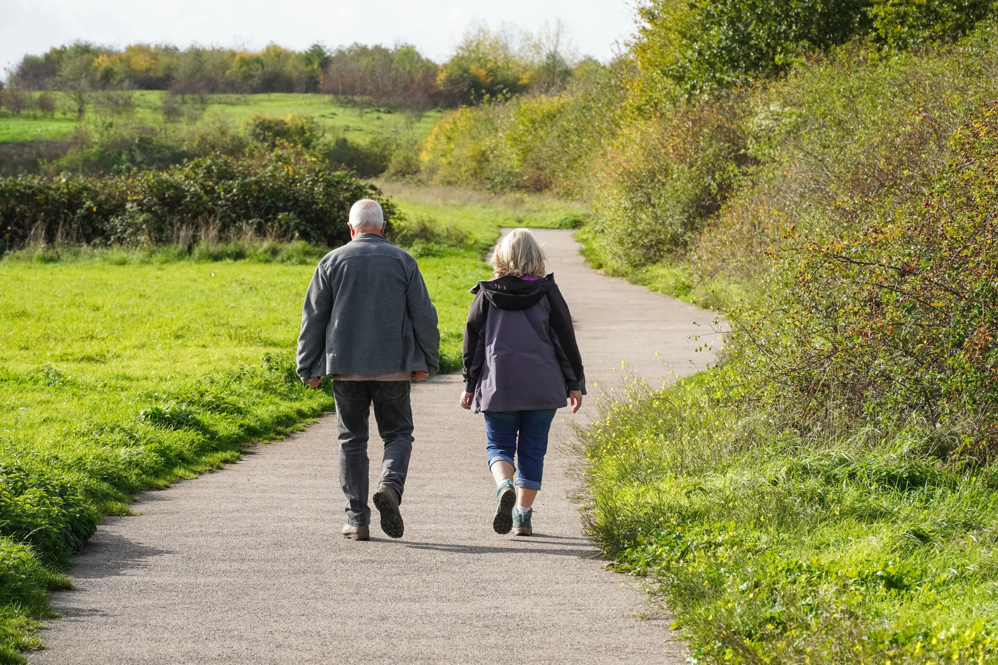 older couple walking down a gravel path
